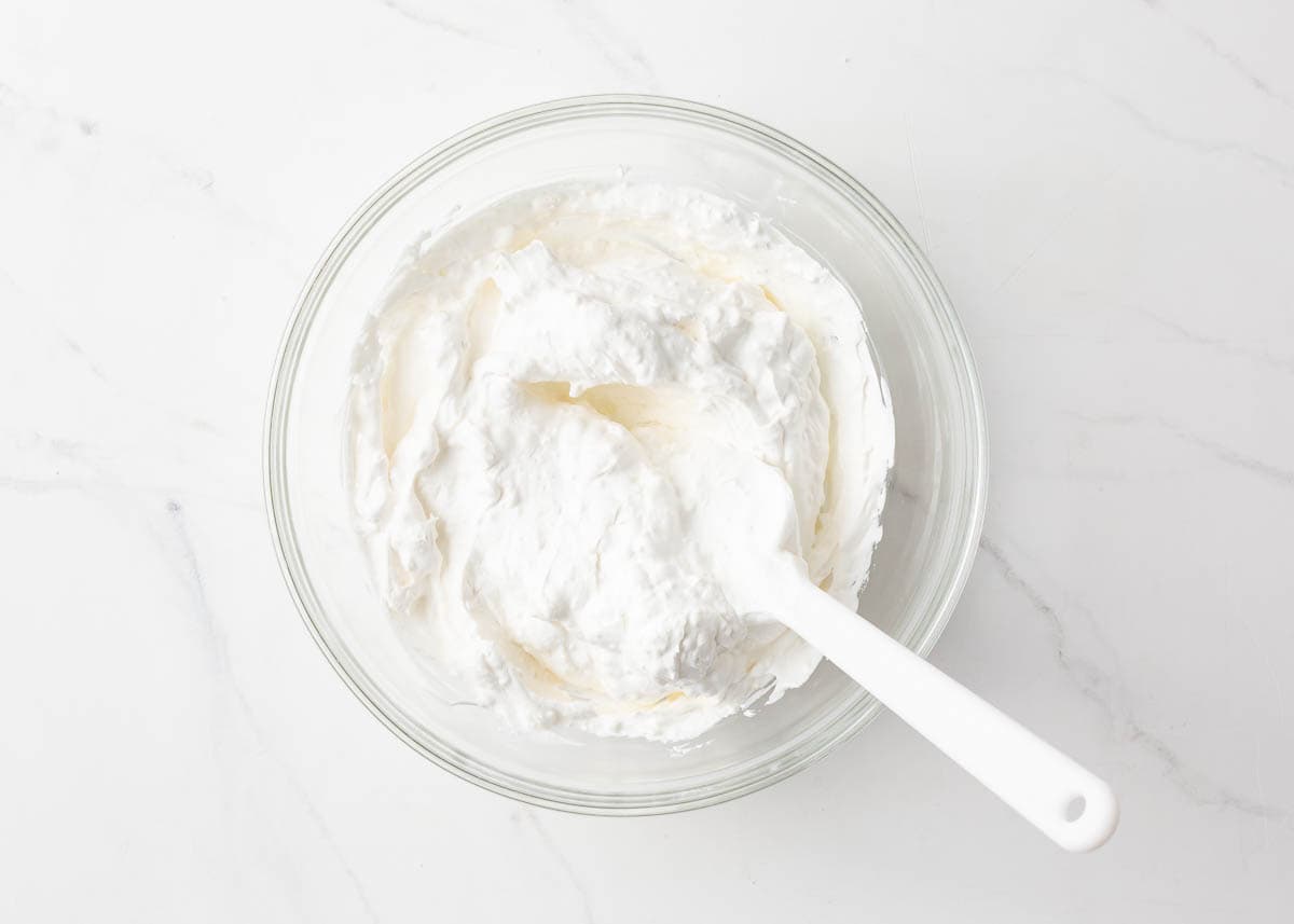 Cream cheese and cool whip combined in a bowl.