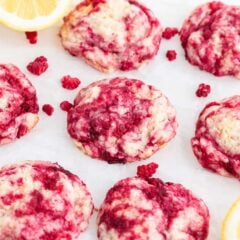 Raspberry cookies on the counter with fresh lemon slices nearby.