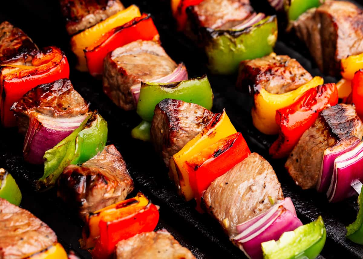 Steak kabobs cooking on grill.