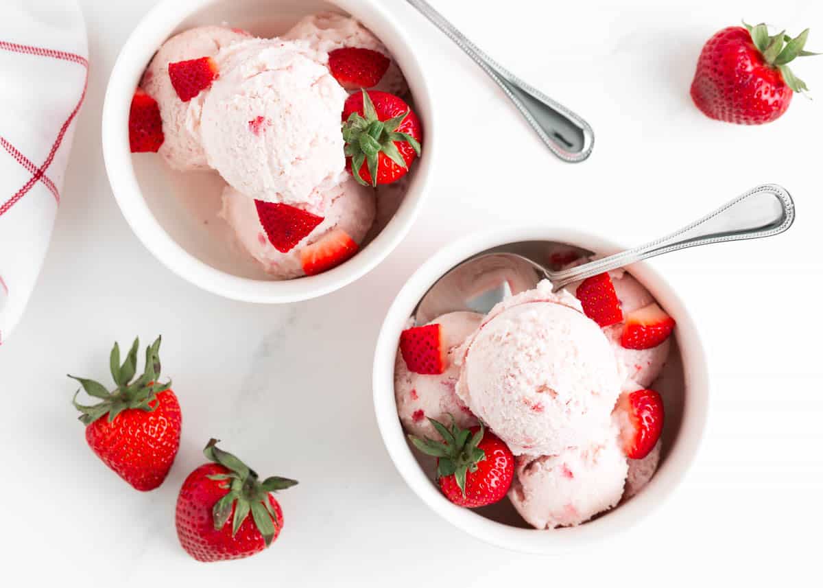 Strawberry ice cream in bowls on counter.