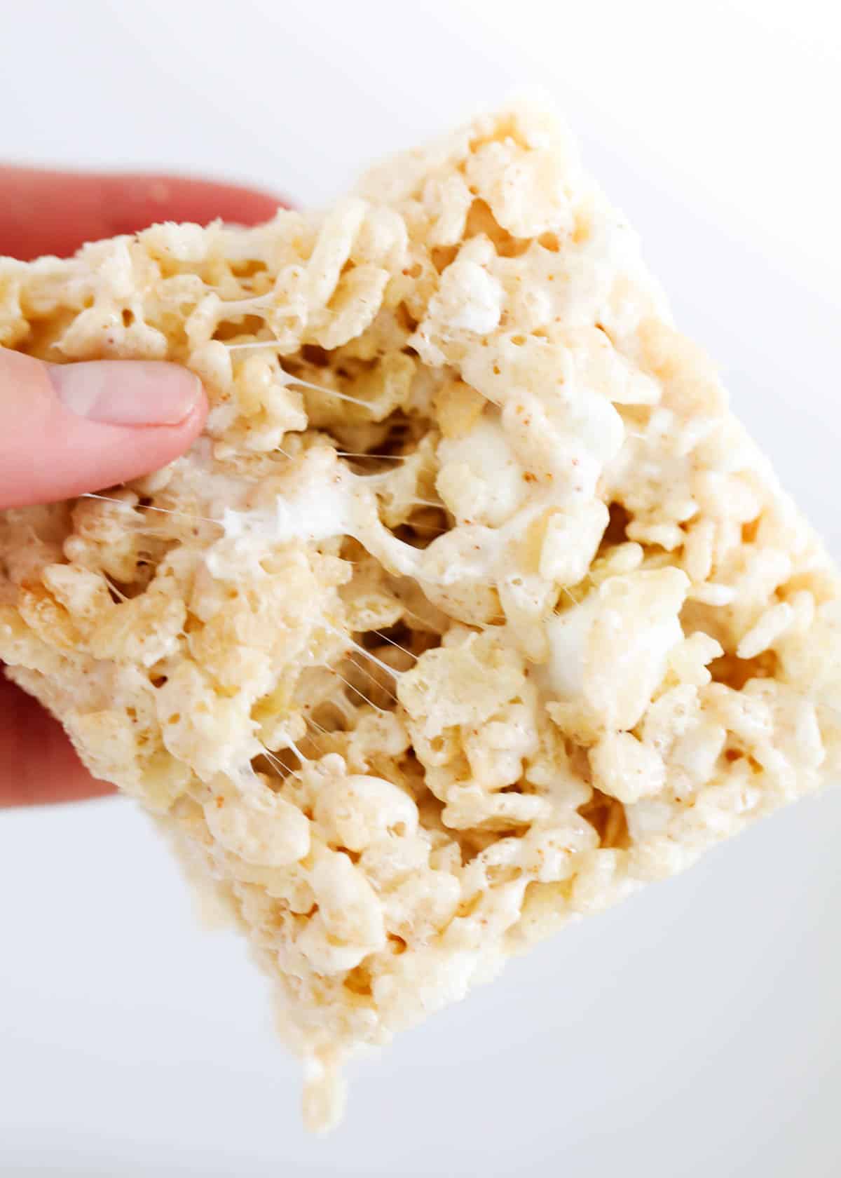 A square of brown butter rice Krispie treat in a hand. 