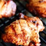 Chicken thighs cooking on the grill.