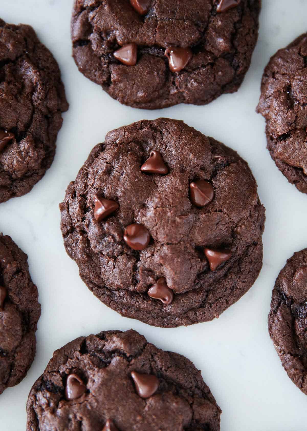 Double chocolate chip cookies on a marble countertop.