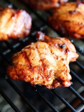 Chicken thighs cooking on the grill.