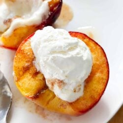 Grilled peaches with cream on a plate.