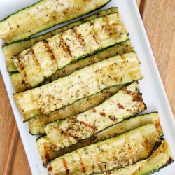 Grilled zucchini on a white plate.