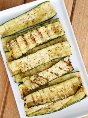 Grilled zucchini on a white plate.
