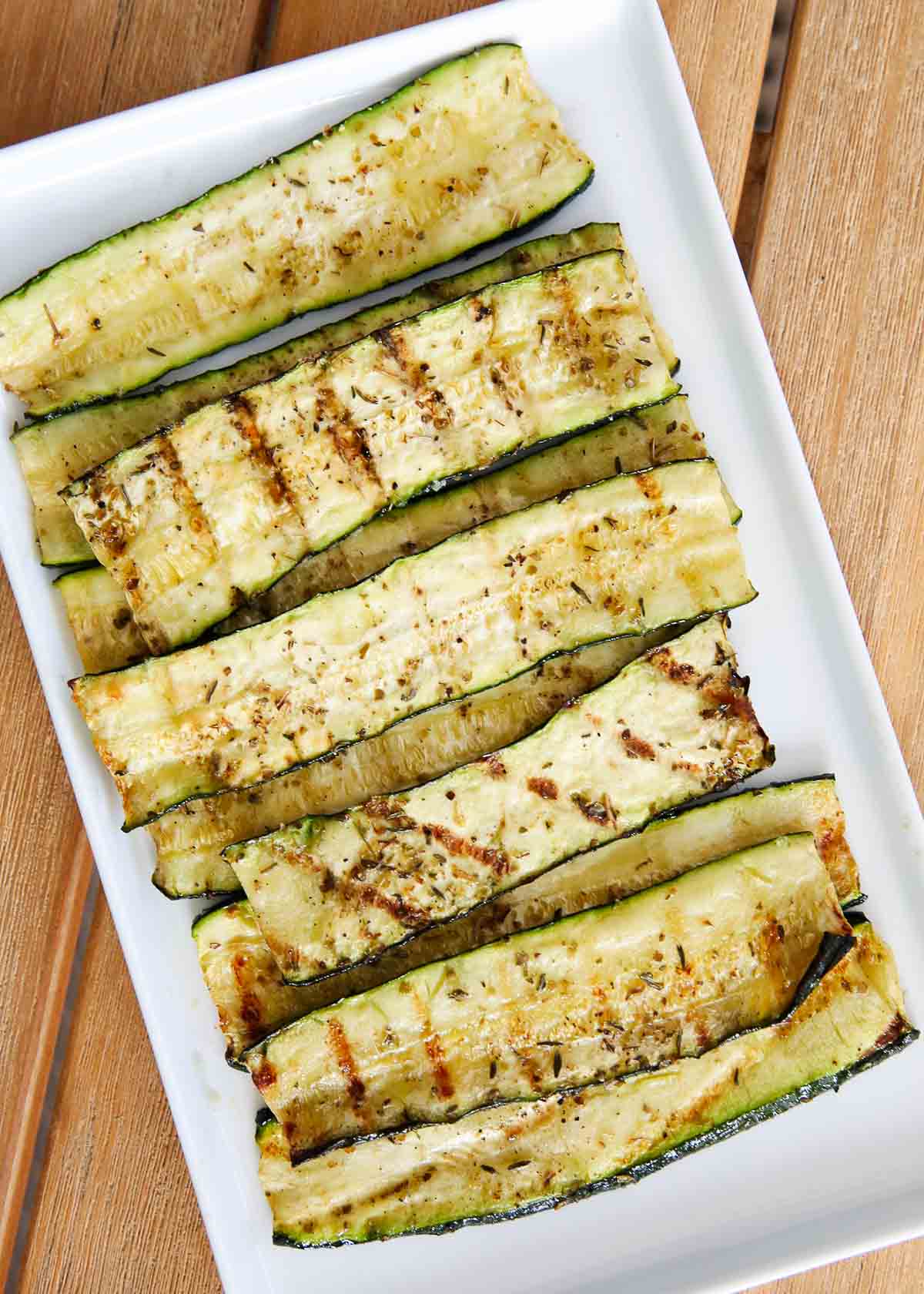 Grilled zucchini on a white plate.
