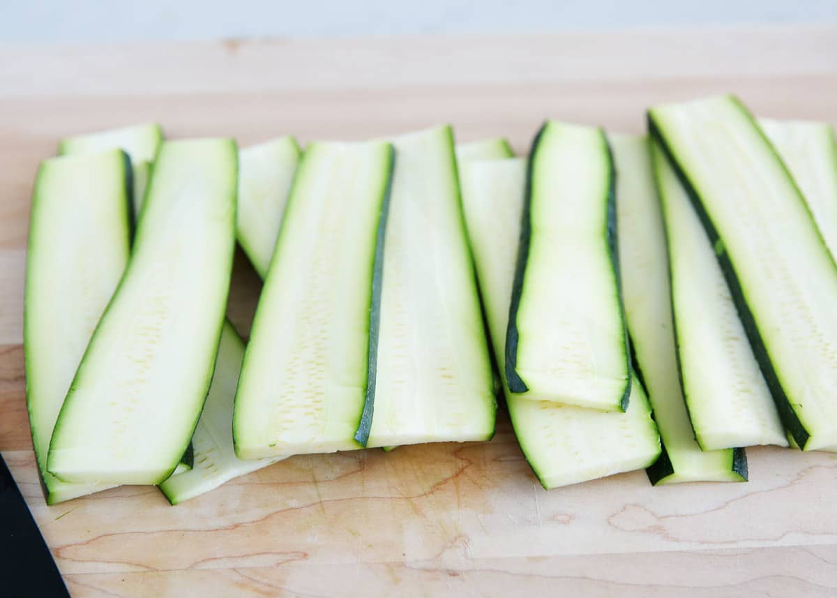 Sliced zucchini on cutting board. 