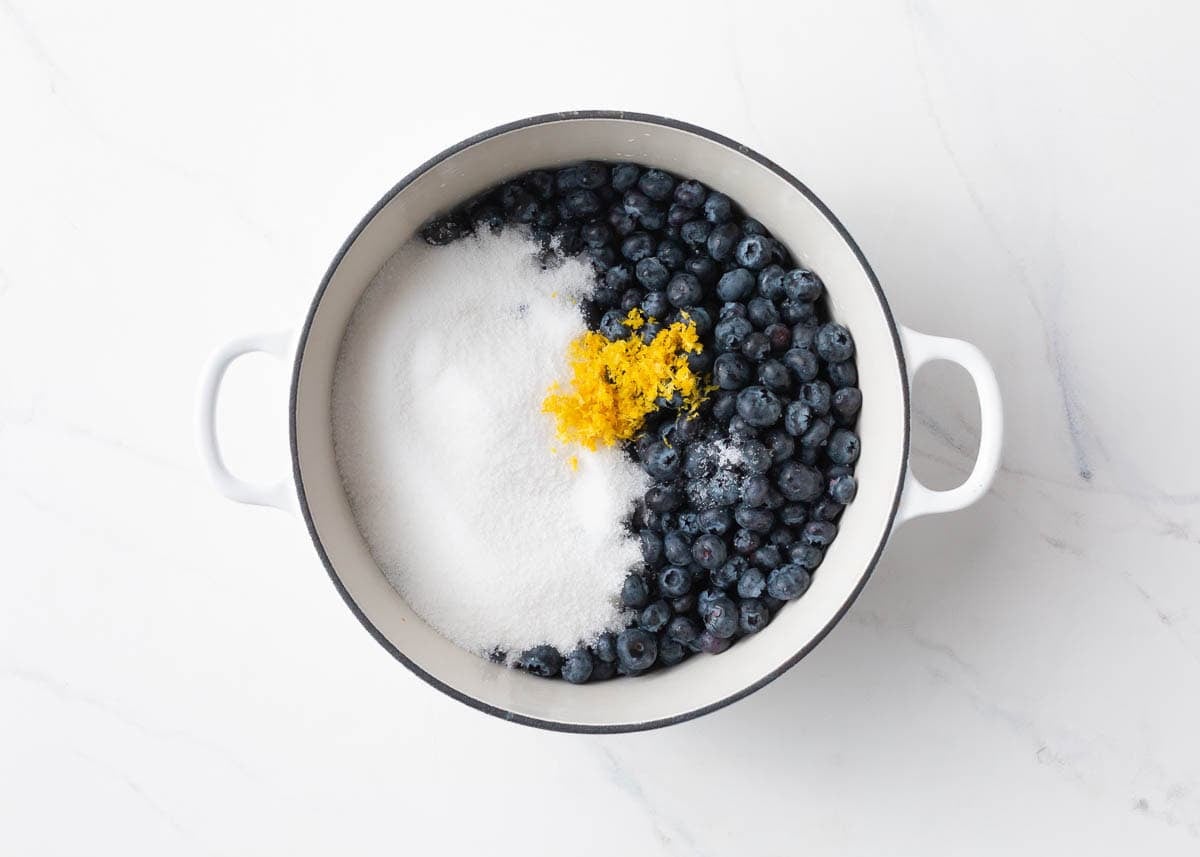 Blueberries, sugar and lemon zest in a saucepan before cooking.