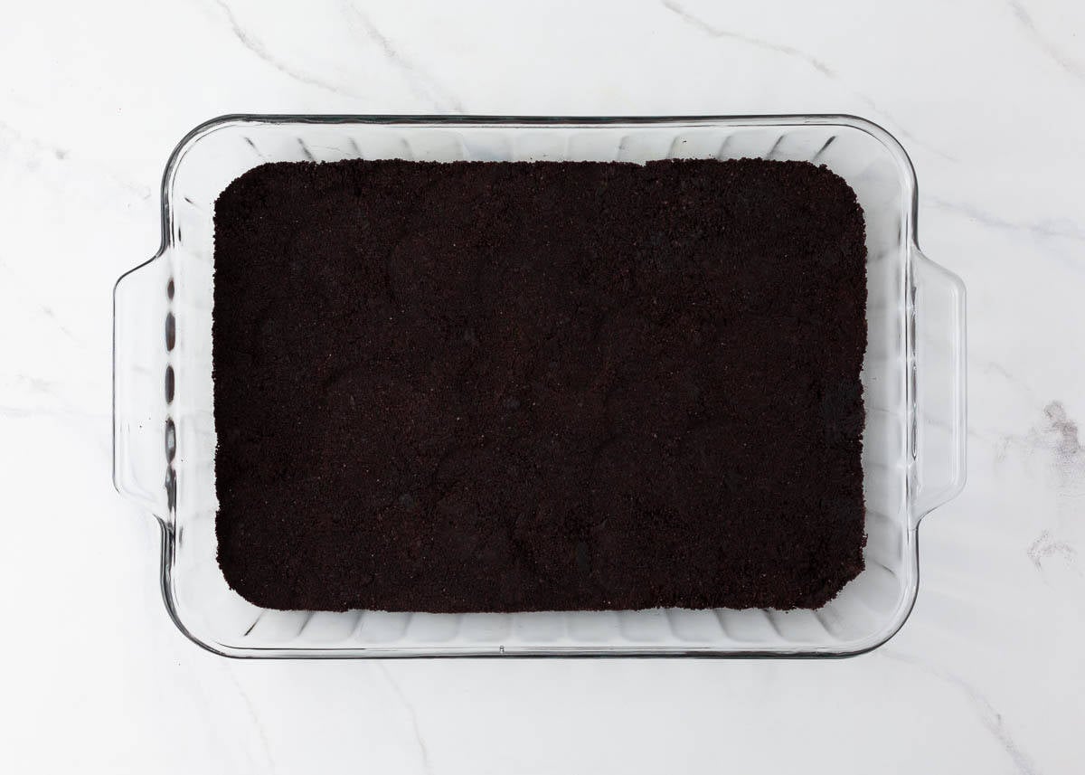 Oreo crust pressed into a 9x13 baking dish.