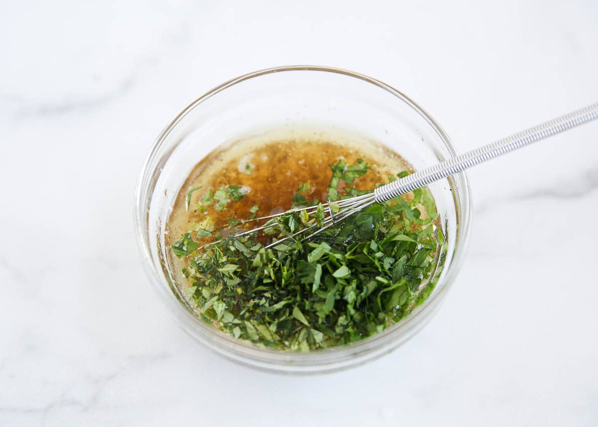 Whisking a greek marinade for kabobs in bowl.
