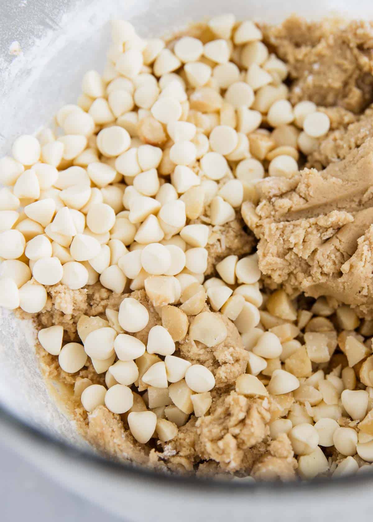 Karıştırma kabında beyaz çikolatalı macadamia fındıklı kurabiye hamuru. 