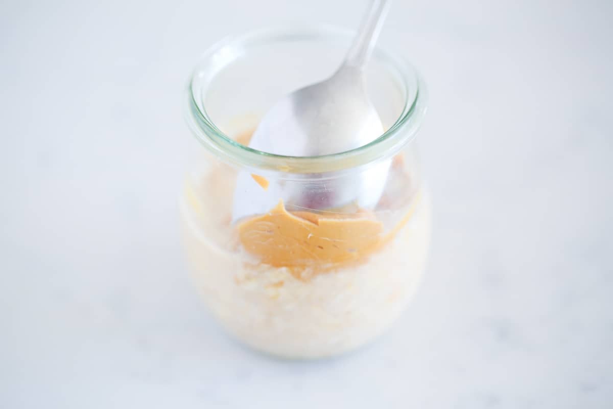 Making peanut butter overnight oats.