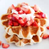 Liege waffles on a white plate with strawberries.