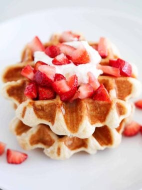 Liege waffles on a white plate with strawberries.