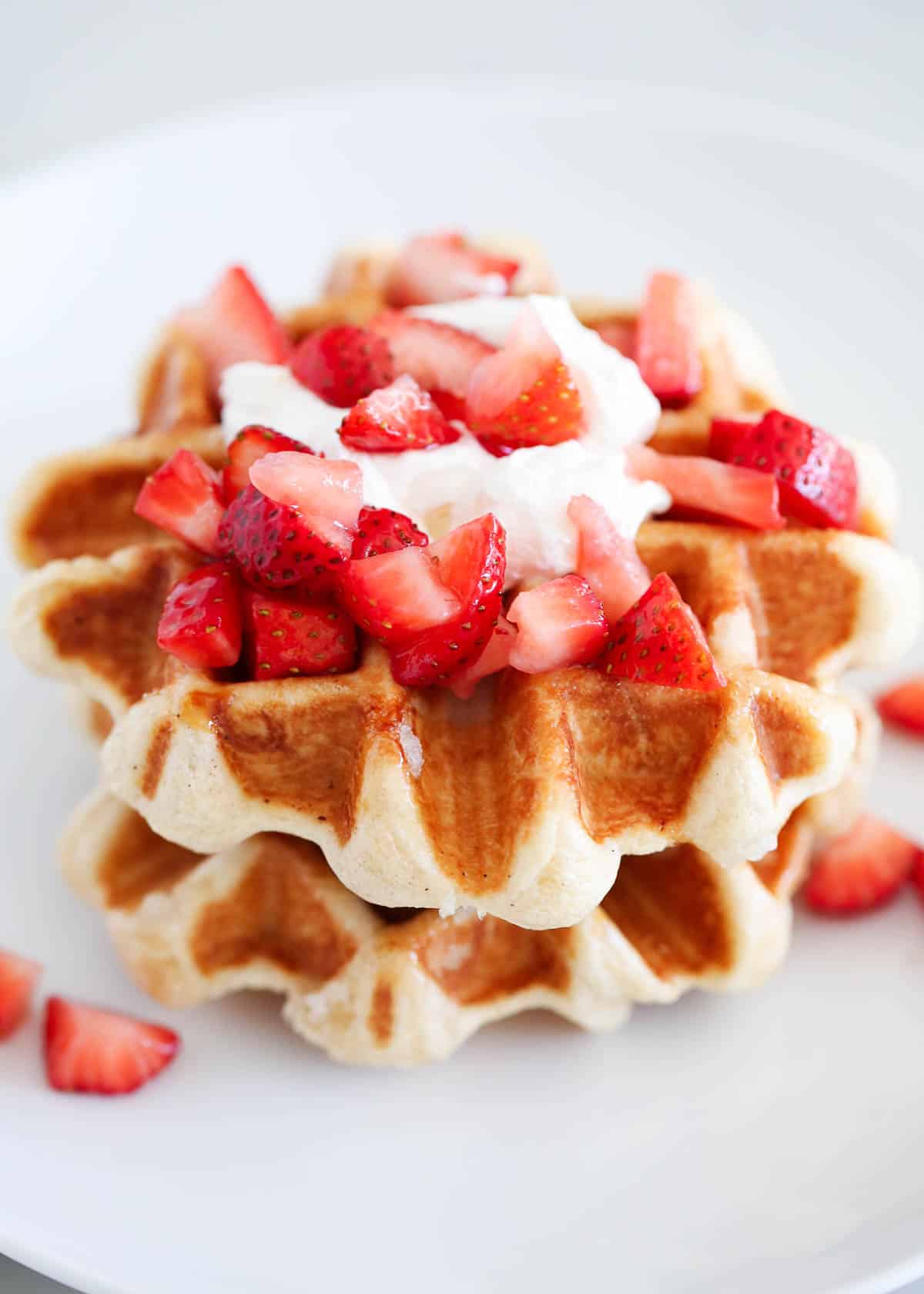 Liege waffles on a white plate with strawberries.