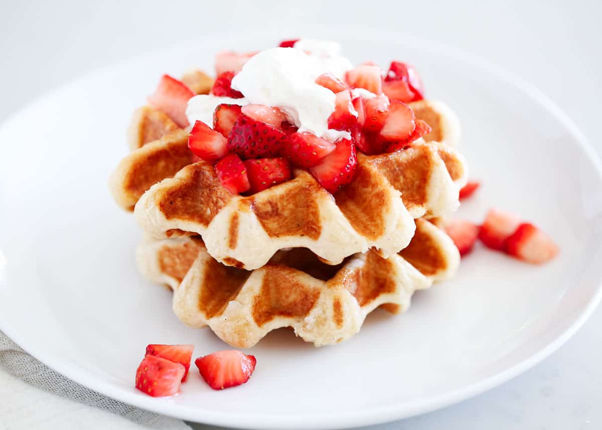 Liege waffles on a white plate with strawberries.