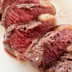 Tender sliced sirloin steak on plate.