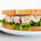 Tuna salad sandwich on a white plate.