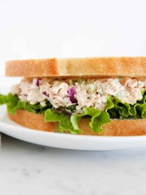 Tuna salad sandwich on a white plate.