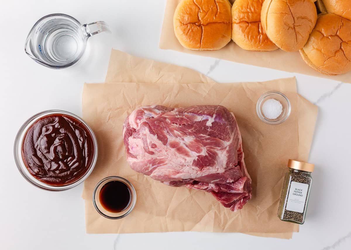 Tender shredded pulled pork smothered in tangy BBQ sauce and served on a toasted hamburger bun. This BBQ pork sandwich recipe is an easy, no-fail dinner idea that takes just 5 minutes to prep! Ingredients for BBQ pulled pork sandwiches including pork shoulder, barbecue sauce, buns, and seasonings.