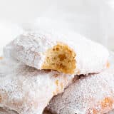 Beignets stacked on a white plate.