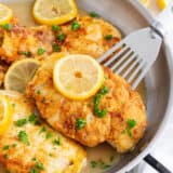 Chicken francese cooking in a skillet.