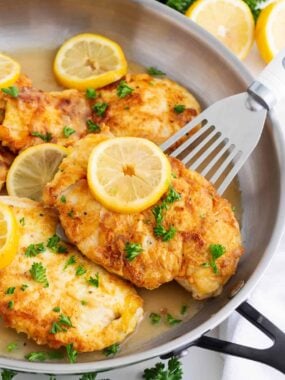 Chicken francese cooking in a skillet.