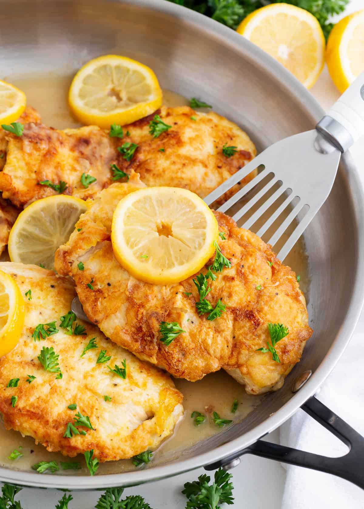 Chicken francese cooking in a skillet. 