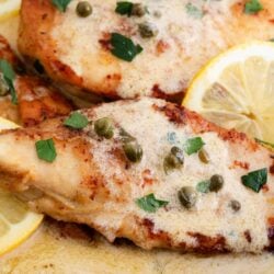 Chicken piccata cooking in a skillet.