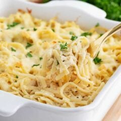 Chicken tetrazzini recipe in a white baking dish with serving spoon.