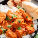 Chicken tikka masala with rice and pita in a bowl.