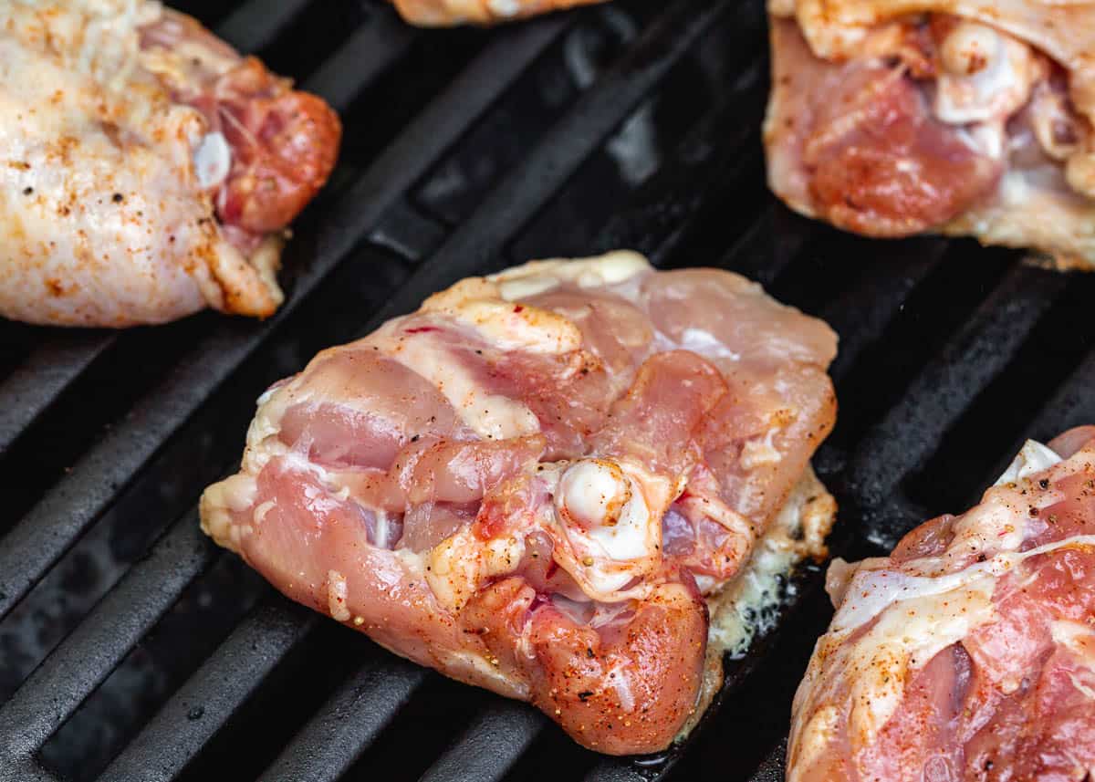 Chicken grilling skin side down over direct heat on the grill. 