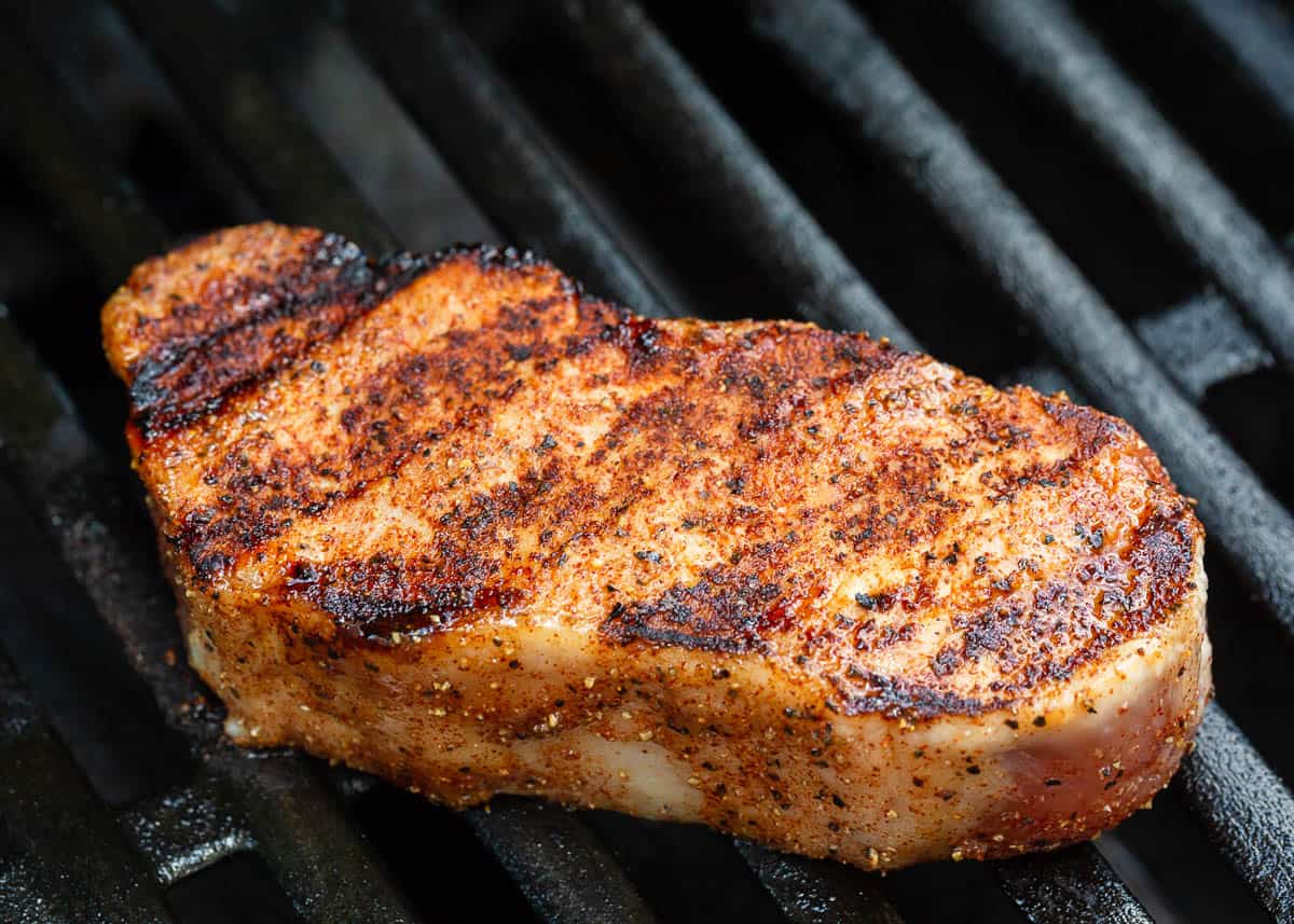A grilled pork chop on the grill.
