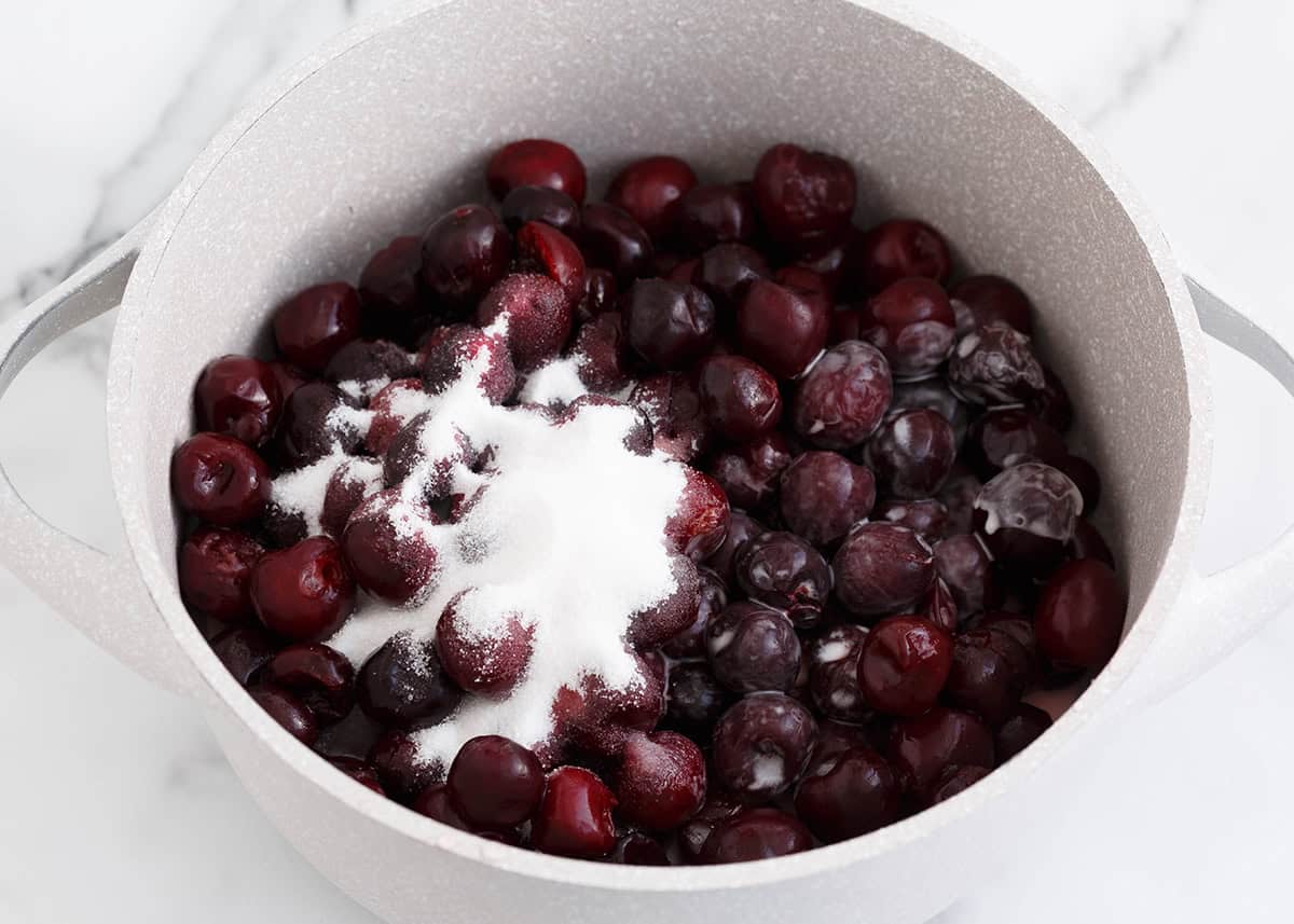 Cherries and sugar in a small pot.