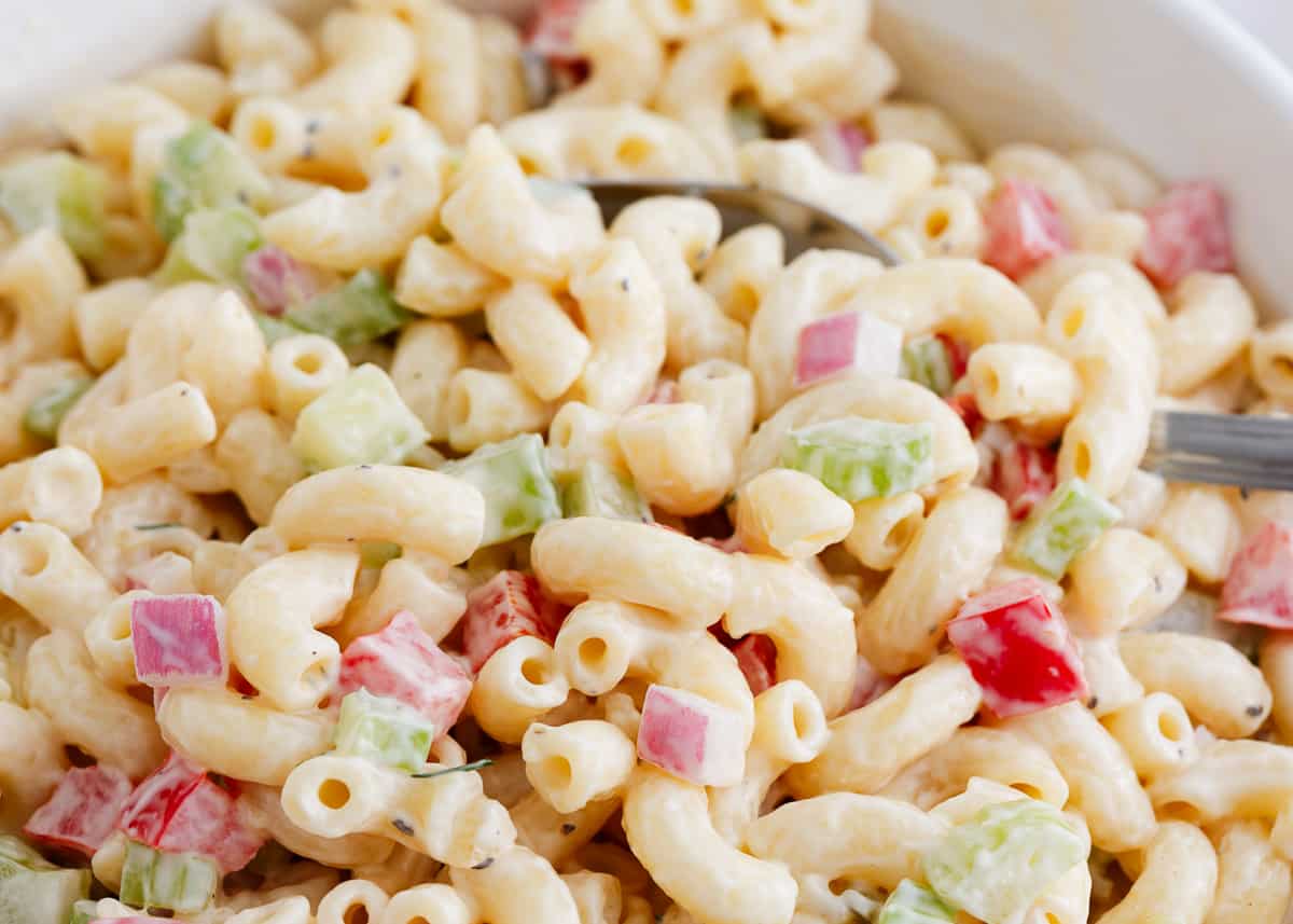 Macaroni salad in a bowl with a spoon.