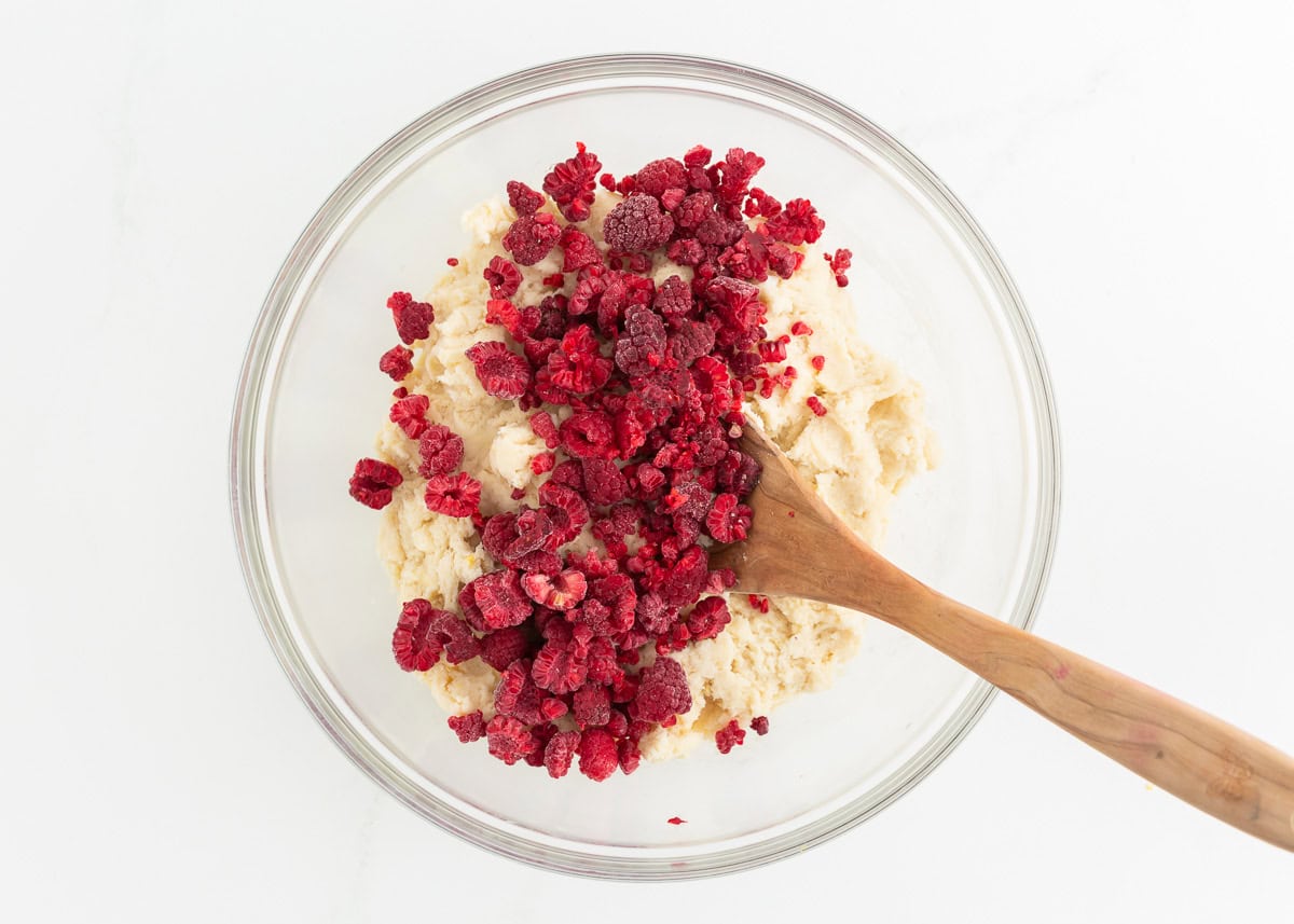 Raspberries being folded into cookie batter.