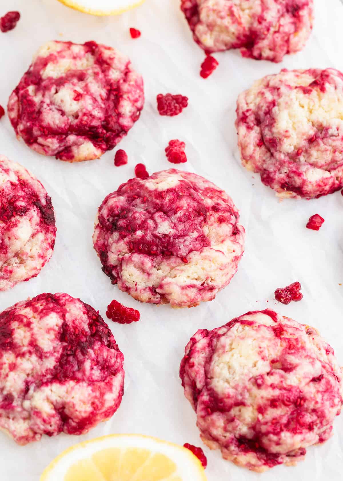Raspberry cookies on the counter with fresh lemon slices.