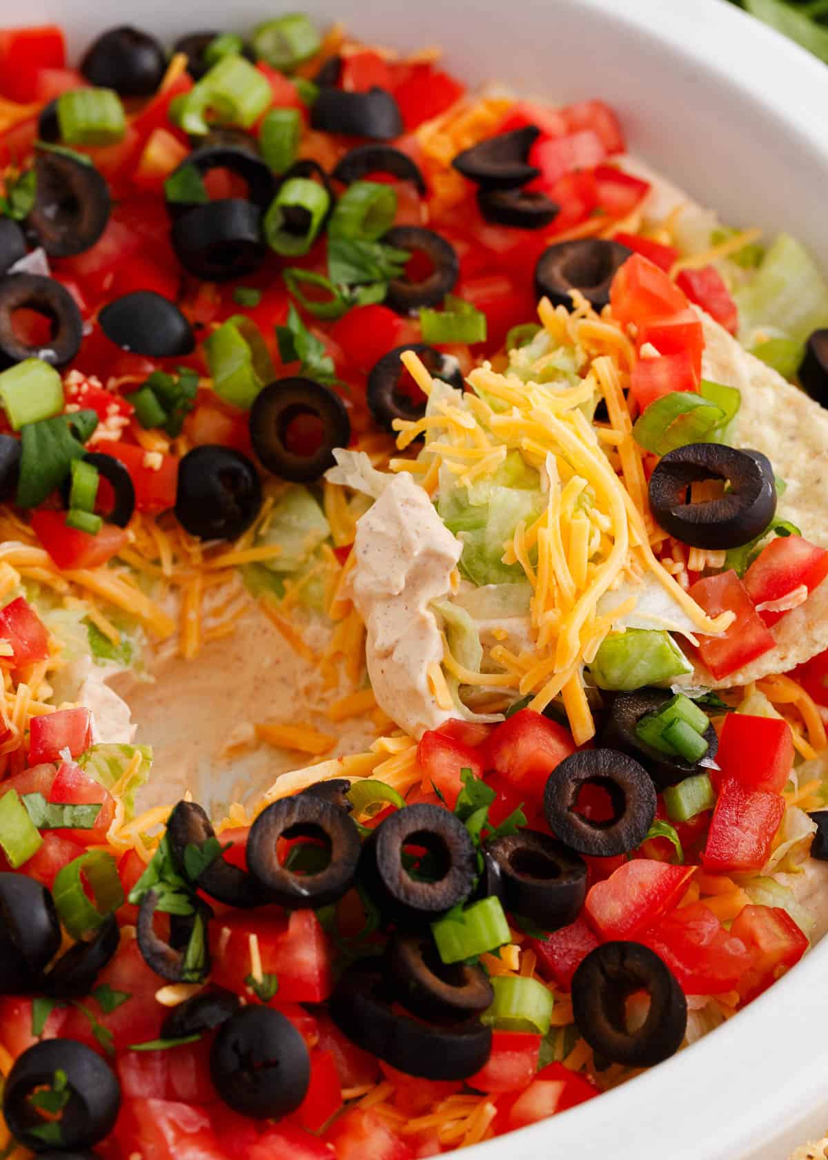 Dipping a tortilla chip into a taco dip.