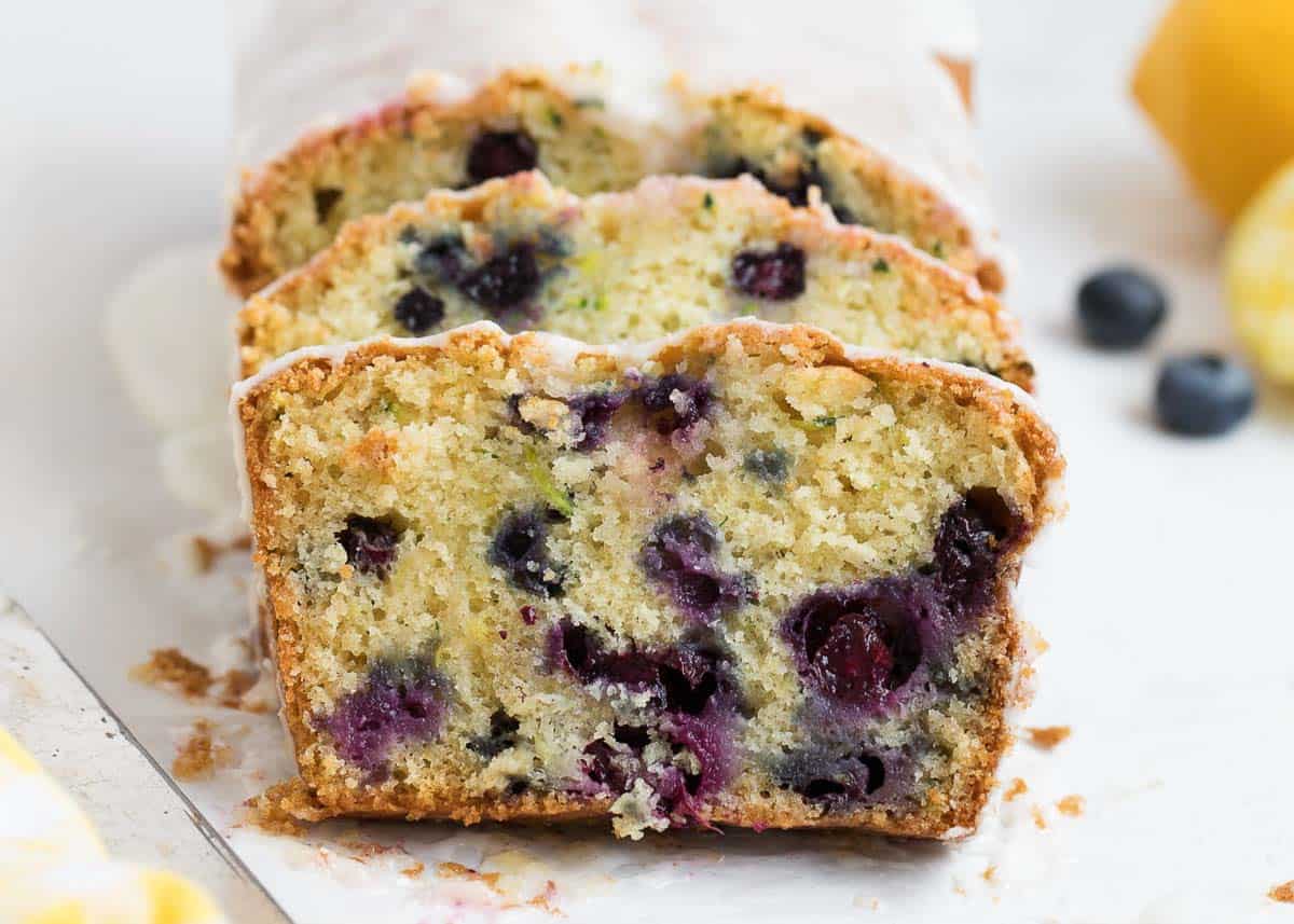 This lemon blueberry zucchini bread is the best I've ever had! It's super moist and full of fresh lemon and blueberry flavor. Then topped with a sweet lemon glaze. Lemon blueberry zucchini bread sliced.