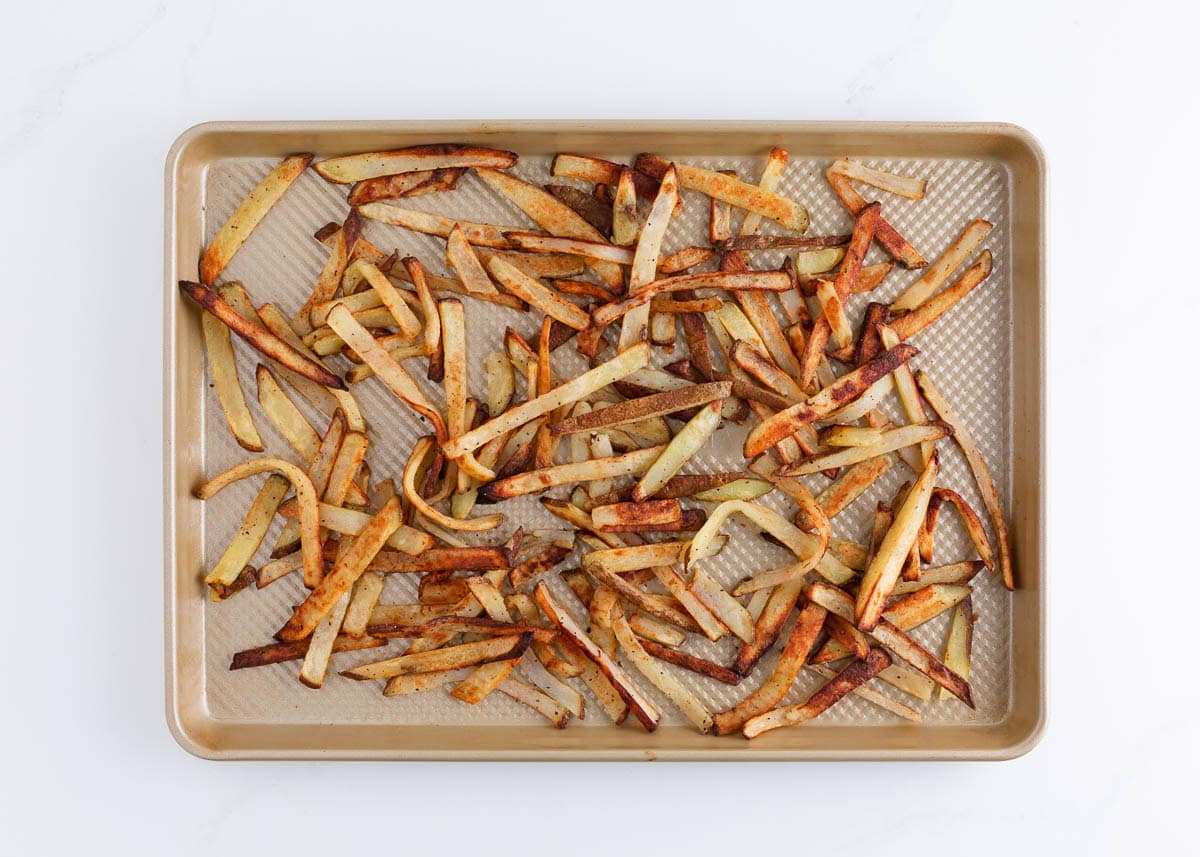 Crispy oven-baked fries on a baking sheet after roasting to golden brown.