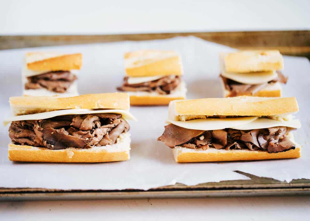 French dip sandwiches on a baking sheet. 