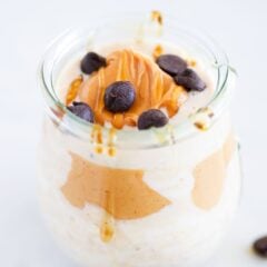 Peanut butter overnight oats in a jar topped with chocolate chips, peanut butter and honey.
