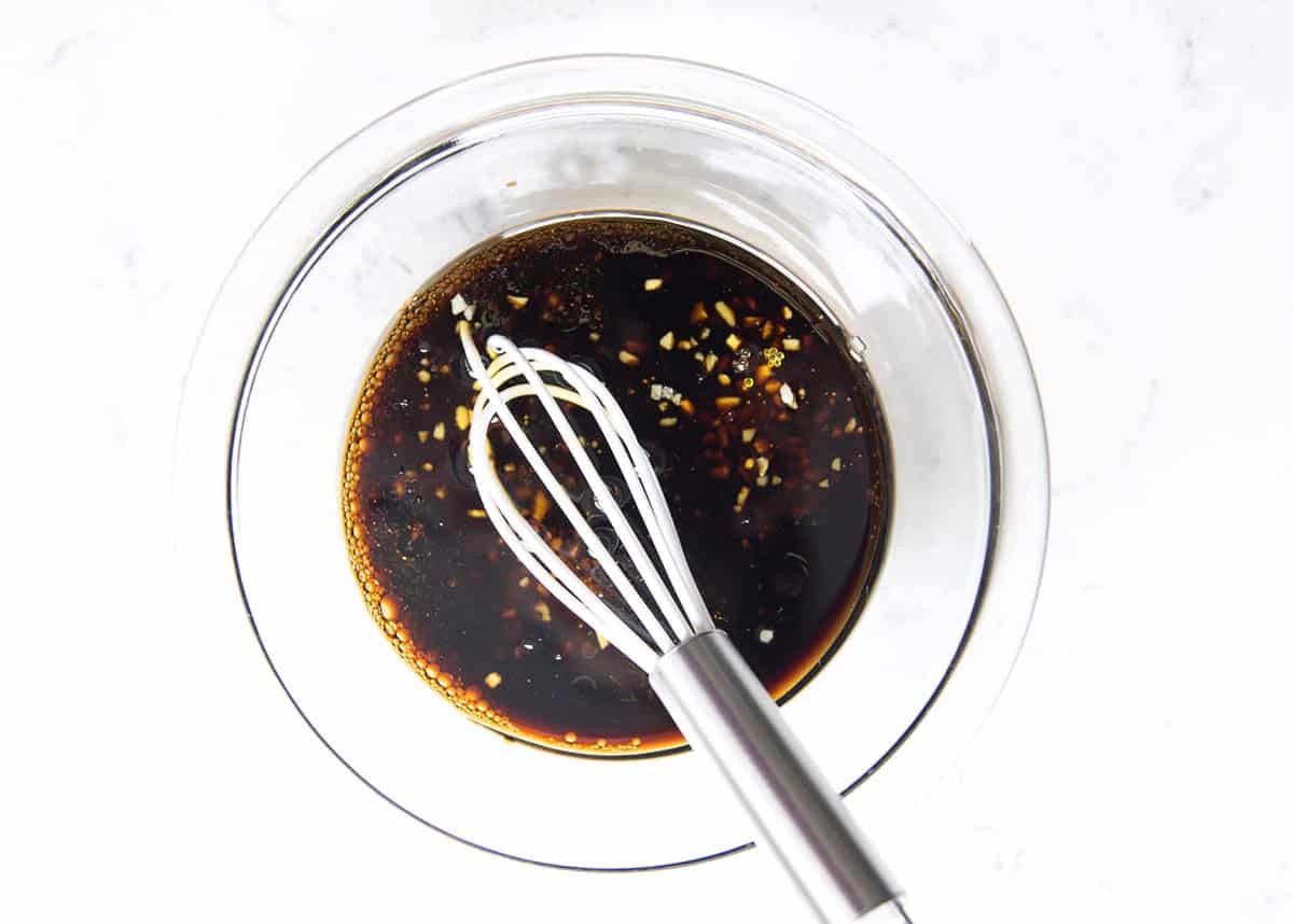 All the marinade ingredients in a glass bowl with a whisk. 