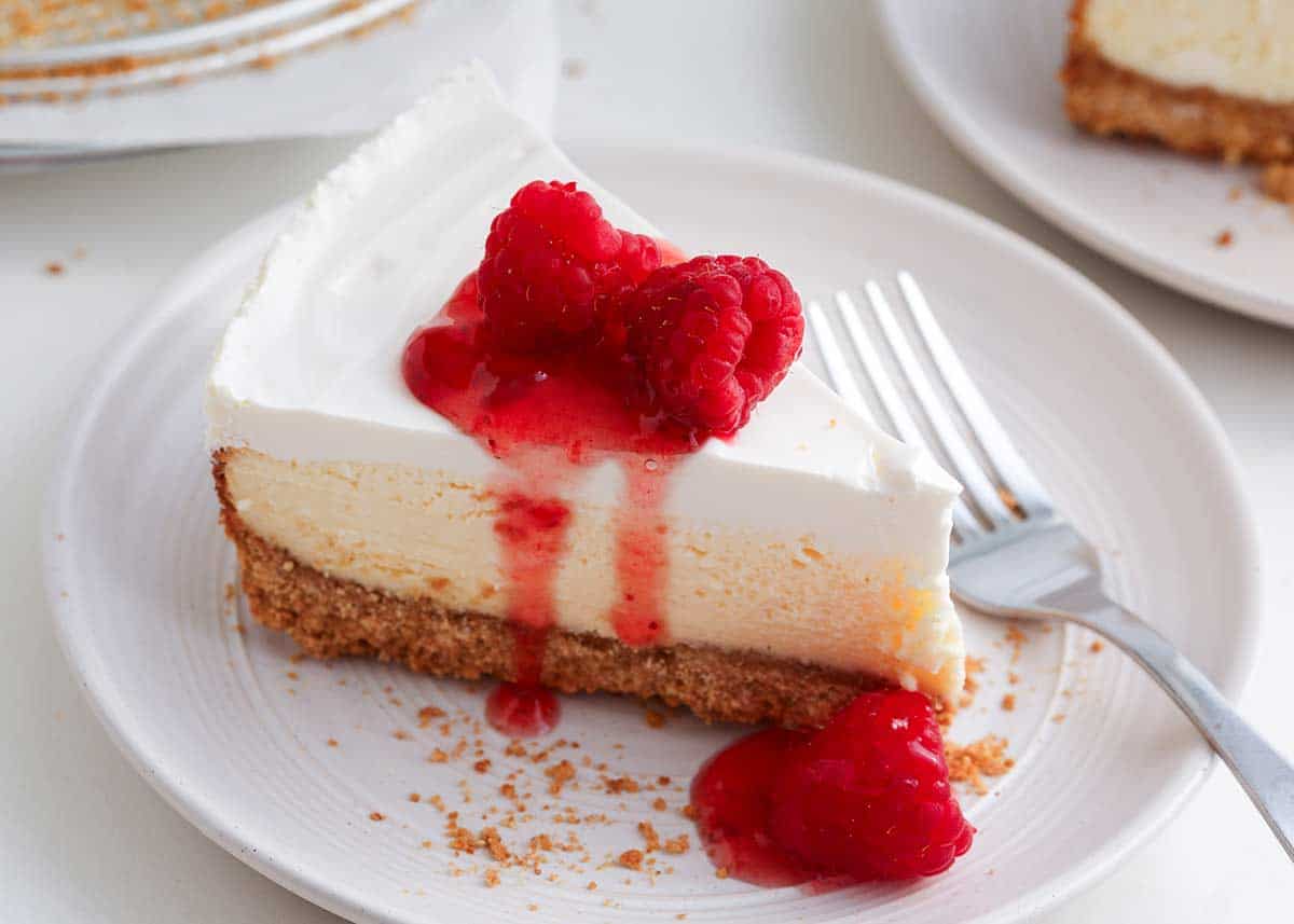 Slice of cheesecake with raspberry sauce.