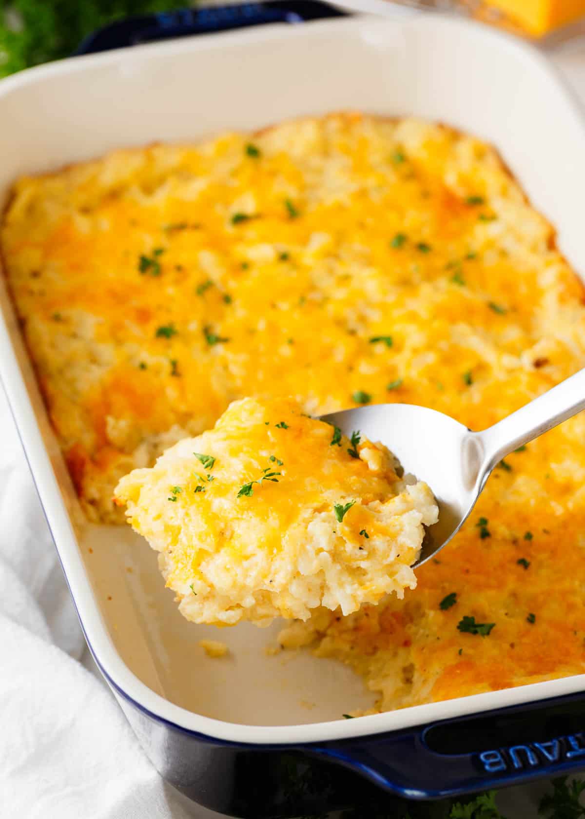 Made with shredded potatoes, simple seasoning, condensed soup, and 2 kinds of cheese, this ridiculously easy cheesy hashbrown casserole recipe is a budget-friendly side dish that is simple to make and a hit with every crowd! Spoonful of hashbrown casserole.