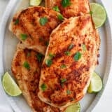 Grilled chicken breast on a white plate.
