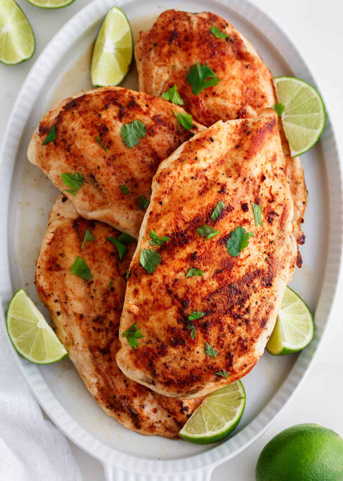 Grilled chicken breast on a white plate.