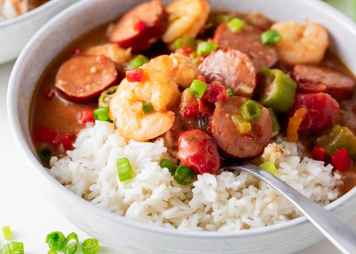 Gumbo in a white dish with a spoon.